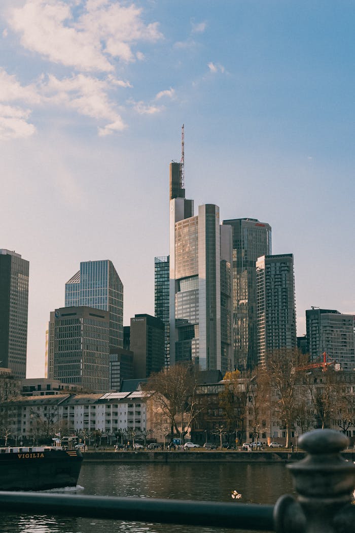 Stunning view of Frankfurts skyline during sunset with reflective skyscrapers and river.